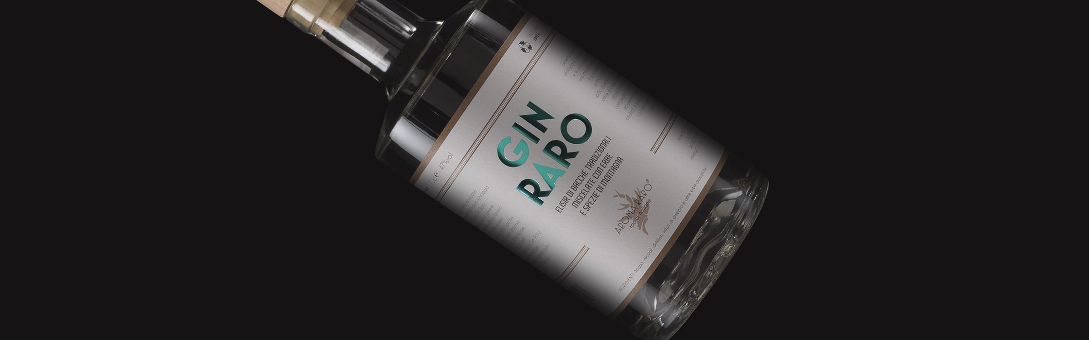 Bottiglia di Gin Raro, distillato artigianale con bacche di ginepro ed erbe alpine, su sfondo nero.
