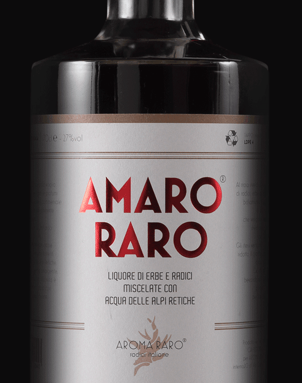 Dettaglio bottiglia di Amaro Raro da 70cl, liquore artigianale italiano con erbe aromatiche e acqua delle Alpi Retiche, su sfondo nero.